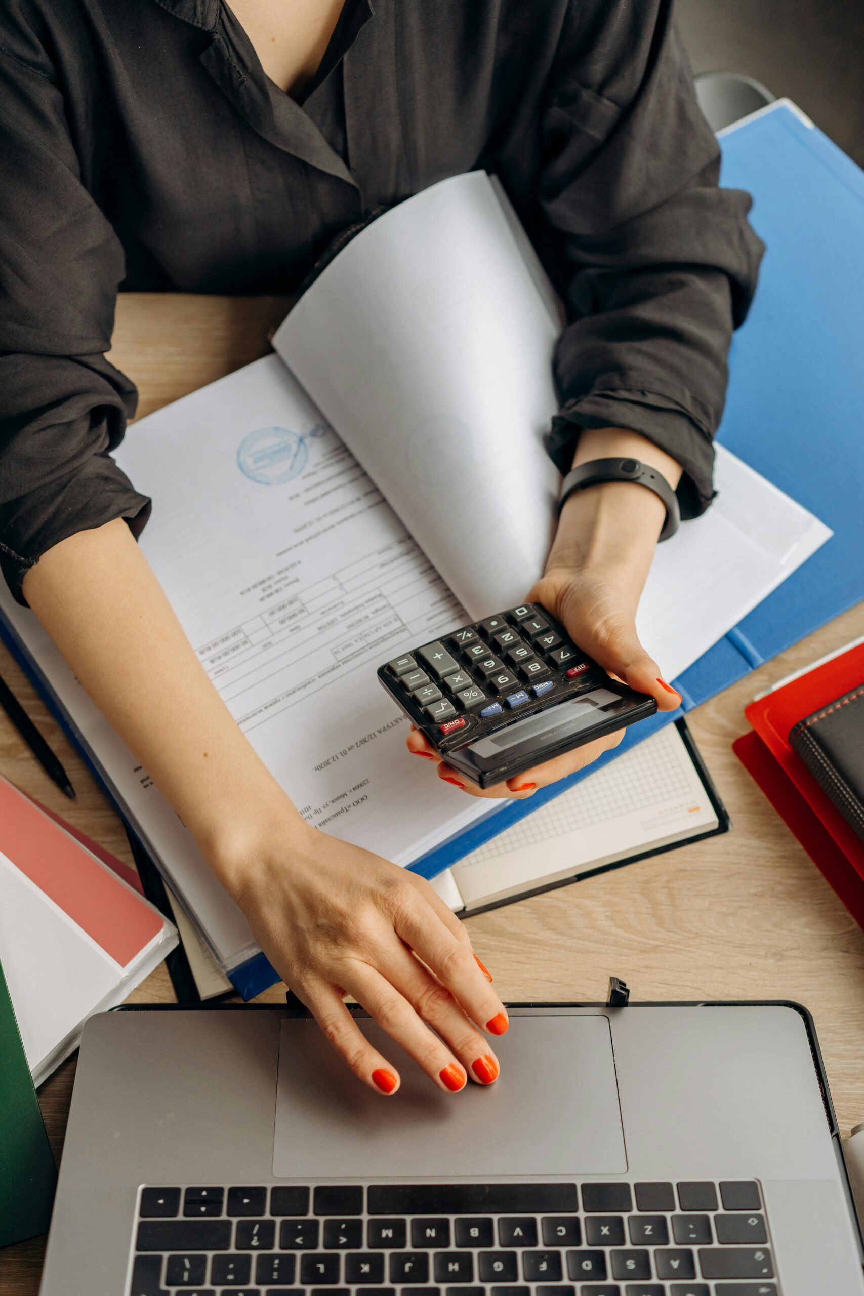 Close up of Business using calculator and laptop for do math finance on wooden desk, tax, accounting, statistics and analytical research concept